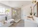 Modern bathroom with a soaking tub, glass-enclosed shower, and double sink vanity at 2571 S Cherokee St, Denver, CO 80223