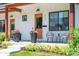 Close-up showcasing the inviting porch with stylish seating, potted flowers, and elegant exterior details at 2571 S Cherokee St, Denver, CO 80223