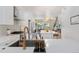 Open kitchen view featuring a large island, stainless appliances, and sight lines into the dining area at 2571 S Cherokee St, Denver, CO 80223