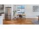 Bright office nook featuring a modern desk, stainless steel refrigerator, and hardwood floors, maximizing space and functionality at 2571 S Cherokee St, Denver, CO 80223