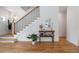 Stylish staircase featuring dark railings, hardwood steps, and a decorative console table, creating an elegant entryway at 2571 S Cherokee St, Denver, CO 80223