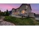 A backyard featuring a deck, grassy yard, and views of a two-story house at dusk at 1805 Parkdale N Cir, Erie, CO 80516