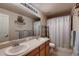 Bathroom with a double sink, large mirror, ship decoration, and shower with curtain at 1805 Parkdale N Cir, Erie, CO 80516