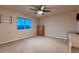 A bright bedroom with a ceiling fan, large window, and neutral-toned walls and carpet at 1805 Parkdale N Cir, Erie, CO 80516