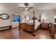 Bedroom features hardwood floors, a four-poster bed, and matching nightstands with lamps at 1805 Parkdale N Cir, Erie, CO 80516