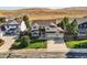 Overhead view of a charming two-story home with a well-kept lawn, mature trees, and attached two-car garage at 1805 Parkdale N Cir, Erie, CO 80516