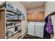 Functional laundry room features washer, dryer, storage shelves, and cabinetry at 1805 Parkdale N Cir, Erie, CO 80516