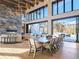 Open dining area with mountain views, a grand stone fireplace, and a spacious table creating an inviting atmosphere at 132 N Gold Flake Ter, Breckenridge, CO 80424