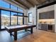 Bright game room features a billiard table, wet bar, wood floors, and stunning mountain views from large windows at 132 N Gold Flake Ter, Breckenridge, CO 80424