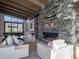 Cozy living room with a stone fireplace and beautiful views of the surrounding landscape at 132 N Gold Flake Ter, Breckenridge, CO 80424