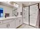 Sleek bathroom featuring a double sink vanity, a glass-enclosed shower with marble-style tiling, and modern fixtures at 3765 W 88Th Ct, Westminster, CO 80031