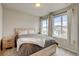 Serene bedroom featuring a platform bed, bedside table, neutral tones, and ample natural light from two windows at 3765 W 88Th Ct, Westminster, CO 80031