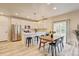 Bright kitchen featuring white cabinets, stainless steel appliances, breakfast bar, and pendant lighting above wooden dining table at 3765 W 88Th Ct, Westminster, CO 80031