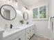 Elegant bathroom featuring dual sinks, sleek black fixtures, and a bright window at 3726 E Nichols Ave, Centennial, CO 80122