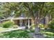 Inviting front of the house with lush lawn, large tree, and manicured landscaping around the walkway to the front door at 3726 E Nichols Ave, Centennial, CO 80122