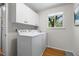 Functional laundry room with a washer and dryer, storage cabinets, and a window at 3726 E Nichols Ave, Centennial, CO 80122