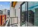 Private balcony with sleek black railings, offering an outdoor space with city views and natural light through sliding glass doors at 2876 W 53Rd Ave # 305, Denver, CO 80221