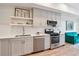 Well-lit kitchen with stainless steel appliances, white cabinets, and a view into the living area at 2876 W 53Rd Ave # 305, Denver, CO 80221