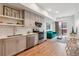 Cozy kitchen open to living area, featuring stainless steel appliances, white cabinets, and hardwood floors, and a green couch at 2876 W 53Rd Ave # 305, Denver, CO 80221