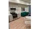 Stylish living space featuring modern appliances, a green futon, and wood-look floors, offering a cozy living area at 2876 W 53Rd Ave # 305, Denver, CO 80221