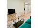 Bright living room with modern decor, a TV stand, and an emerald green couch at 2876 W 53Rd Ave # 305, Denver, CO 80221