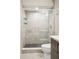 Close-up of a shower with glass doors and decorative tile in a modern bathroom at 1386 Zenobia St, Denver, CO 80204