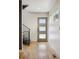 Foyer showcasing light hardwood floors and stairs with metal railing at 1386 Zenobia St, Denver, CO 80204