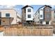 Modern three-story home featuring a well-maintained lawn and privacy fence at 1386 Zenobia St, Denver, CO 80204
