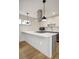 Stylish kitchen island with a built-in stovetop under modern pendant lighting, alongside sleek cabinetry and stainless steel appliances at 1386 Zenobia St, Denver, CO 80204