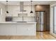 Modern kitchen with white countertops, stainless steel appliances, a stylish range hood, and sleek pendant lighting at 1386 Zenobia St, Denver, CO 80204