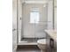 Glass enclosed shower with white tile and dark gray floor at 1386 Zenobia St, Denver, CO 80204