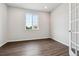 Bright bedroom featuring a large window, wood-look floors, and white walls and trim at 13920 Hanging Lake St, Parker, CO 80138