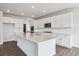 Bright kitchen features white cabinetry, an island, stainless appliances, and wood flooring at 13920 Hanging Lake St, Parker, CO 80138