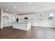 Bright kitchen features white cabinetry, an island, stainless appliances, and wood flooring at 13920 Hanging Lake St, Parker, CO 80138