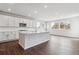 Bright kitchen features white cabinetry, an island, stainless appliances, and wood flooring at 13920 Hanging Lake St, Parker, CO 80138