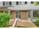 Charming townhouse front entrance with brick facade, decorative door, and well-manicured landscaping at 9930 W Progress Pl, Littleton, CO 80123