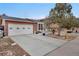 Welcoming exterior showcasing a spacious driveway and well-kept lawn with mature trees, complemented by a two-car garage at 1301 S Yampa Ct, Aurora, CO 80017