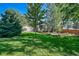 Spacious backyard with lush lawn and partial view of home at 7115 Geneva Ct, Lakewood, CO 80214