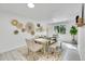 Light and airy dining room with a rustic wood table and neutral decor at 7115 Geneva Ct, Lakewood, CO 80214