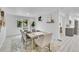 Modern dining room featuring a white brick accent wall and light wood furnishings at 7115 Geneva Ct, Lakewood, CO 80214