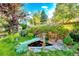 Beautiful backyard featuring a tranquil koi pond with mature trees and landscaping at 7681 S Jellison St, Littleton, CO 80127