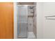 Bathroom showing tiled shower with sliding door and a towel bar and wooden door nearby at 7681 S Jellison St, Littleton, CO 80127