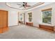 Spacious bedroom showing ceiling fan, carpeting, and a walk-in closet with mirror at 7681 S Jellison St, Littleton, CO 80127