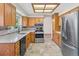 Bright kitchen features modern appliances, wood cabinets, tile floors, and white countertops at 7681 S Jellison St, Littleton, CO 80127