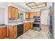 Well-lit kitchen featuring stainless steel appliances, light wood cabinetry, and tiled backsplash detail at 7681 S Jellison St, Littleton, CO 80127