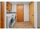Laundry room boasting a modern washer and dryer set, tiled flooring, cabinets, and door at 7681 S Jellison St, Littleton, CO 80127
