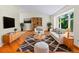 Bright living room with hardwood floors, large windows, and stylish furniture at 7681 S Jellison St, Littleton, CO 80127