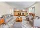 Bright living room featuring a fireplace, hardwood mantle, a gray sofa and chairs and a patterned rug at 7681 S Jellison St, Littleton, CO 80127