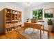 Bright home office with a bookshelf, desk, wood floors, a patterned rug, and a bright window at 7681 S Jellison St, Littleton, CO 80127