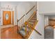 Carpeted staircase with wood railings, leading to the upper level, and hardwood flooring in entry at 7681 S Jellison St, Littleton, CO 80127